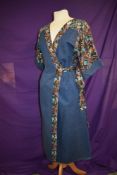 A 1970s vintage wrap around denim dress using floral fabric to sleeves.