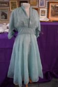 A 1950s dress having sheer flocked floral fabric over sea green lining,side metal zip, larger size.
