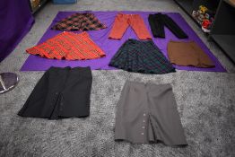 A collection of vintage skirts and a pair of tartan trousers.