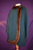 A stunning teal blue 1960s coat having mink trim and bow detail,all wool and worsted.