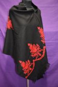 A black Kashmir wool shawl having red embroidery.