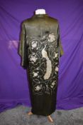 An early to mid 20th century kimono in olive green having metallic thread work depicting a peacock