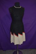 A 1960s striking linen day dress having black and cream ground with contrasting red zip zagged