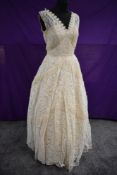 A 1950s lace wedding dress having georgette tiers, full skirt with straps to illusion bodice and