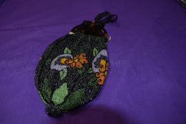 A Victorian beaded evening bag having tortoiseshell or similar carved handles.