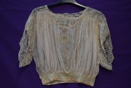 An Edwardian sheer crepe georgette and lace bodice in cream with pink accents.