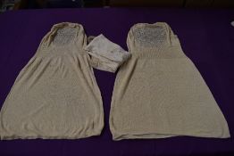 A pair of cream Edwardian stockings and two sleeveless modesty panel vests.
