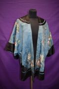 An exquisitely embroidered antique Chinese silk jacket in pale blue and black with pastel