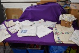 A selection of vintage and antique embroidered tray and table cloths.