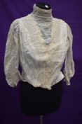 An Edwardian cotton bodice having lacework and pin tuck details.