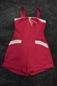A 1950s Cerise and white cotton playsuit having pockets to front and button fastening to back.