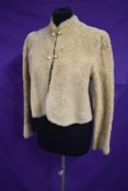 An early 20th century short cream fine sheepskin jacket with silk lining.