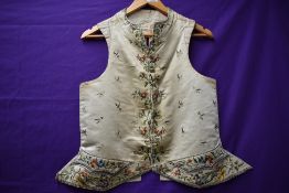 A gents antique cream silk fronted waistcoat having extensive embroidery, cloth backed with tie