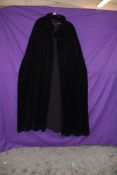 An early 20th century black velvet cape having crepe lining.