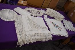 An assortment of tray and table cloths including drawn thread example.