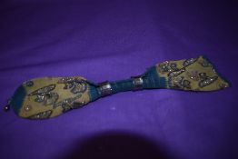 A late Georgian/early Victorian misers purse having original cut steel bands and embroidery.