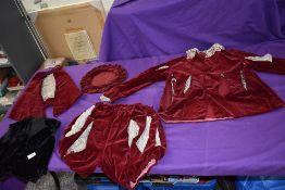 A vintage Tudor style page boys outfit in red velvet, jacket having slashed sleeve detailing and