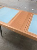 A modern beech and glass dining table having tambour style pull put extension