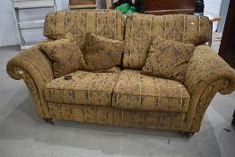 A modern settee in the traditional style, having turned legs and brass castors, looks a nice