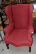 A traditional wing back armchair upholstered in red tweed style fabric, good heavy frame