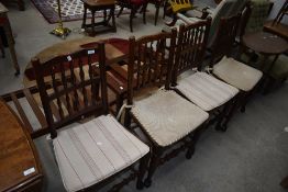 A set of four traditional spindle back kitchen dining chairs having rush seats