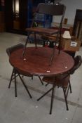 A vintage folding metal circular table and set of three similar chairs, labelled Cosco, with vinyl