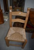 A set of six quality modern/vintage beech ladder back kitchen chairs having rush seats,