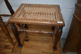 A traditional oak stool having canework seat
