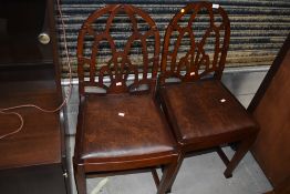 A pair of period style oak dining chairs, having Gothic arch backs with chamfered legs