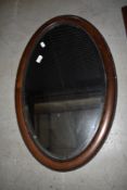 An early 20th Century oak oval wall mirror