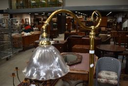 An Art Nouveau style brass standard lamp having pressed glass shade