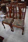 A set of four early 20th Century mahogany dining chairs having vase backs, drop in seats and
