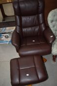 A modern brown leatherette easy chair and footstool