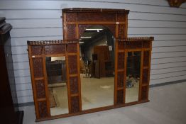 A Victorian overmantel mirror having integrated fretwork decoration, some damage to top beading