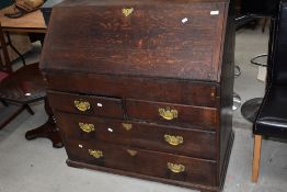 A 19th century oak bureau of traditional fall front design with concealed section and 2 short and