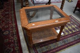A modern stained frame coffee table having glazed top and bergere canework undertier, approx 68 x