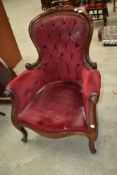 A Victorian button back armchair having dralon uphostery on scroll frame