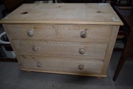 An antique stripped pine chest of two over two drawers