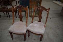 A pair of early 20th Century mahogany lounge chairs having carved back , upholstered seats and