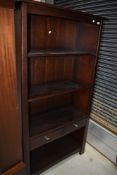 A modern mahogany bookshelf with central drawer section, width approx. 100cm