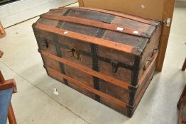 A large vintage dome top bedding trunk having leather strap work, width approx. 94cm