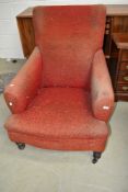 A Victorian low seat armchair with turned mahogany legs and later moquette upholstery