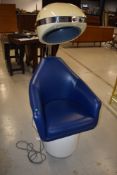 A vintage commercial style hairdryer having blue vinyl seat