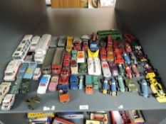 A shelf of Dinky playworn diecasts including Racing Cars, Police Vans, 8 Wheel Wagons also seen,