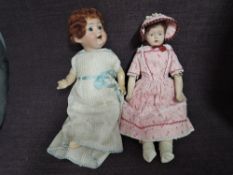 An early 20th century German bisque headed doll having sleep blue eyes, open mouth with two teeth