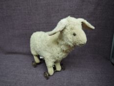 A possible Steiff or Steiff style straw filled white plush Lamb on wheels having stitched nose and