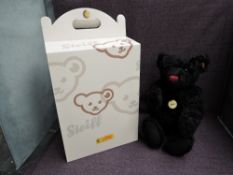 A modern Steiff Black Bear 005985 with yellow tag and button, growling mechanism and boxed,