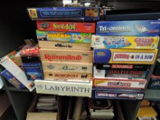 A shelf of mainly modern games including Guess Who, Monopoly, Scrabble, Rummikub, Cludo, Hangman