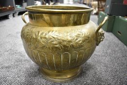 A William Souter & Sons embossed brass planter, with applied mask handles, embossed foliate and