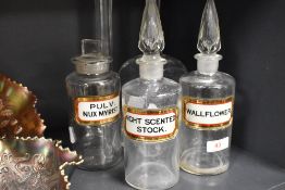 A group of three clear glass chemists bottles, with labels, an R Douglas (London W) bottle and two